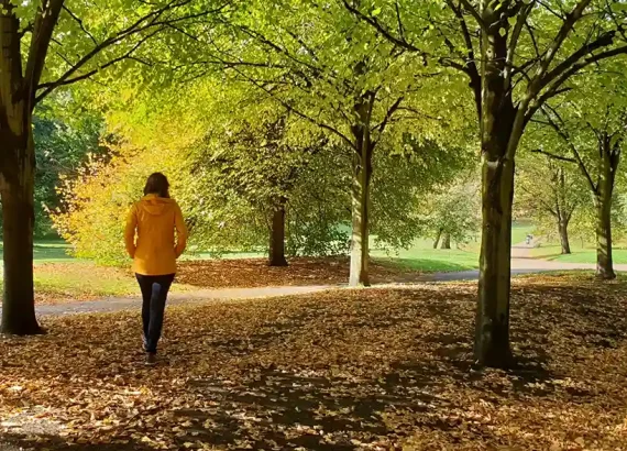 Girl walking in a park in autumn colours