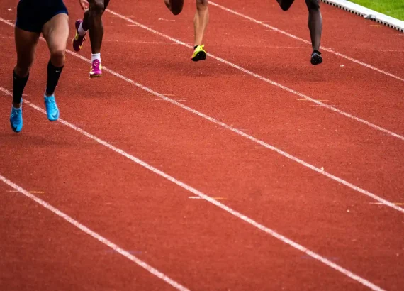 Close-up-view-of-athletes-legs-in-motion-during-a-sprint-on-a-red-running-track-capturing-the-intensity-of-sprint-interval-training