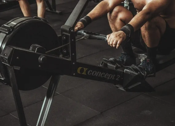 Close-up of an athlete performing a seated row exercise on a rowing machine, emphasizing the equipment used in strength training workouts