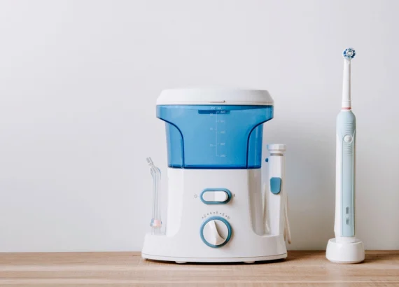 Electric water flosser and toothbrush displayed on a wooden countertop