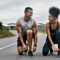 couple tying shoes for cardio exercise