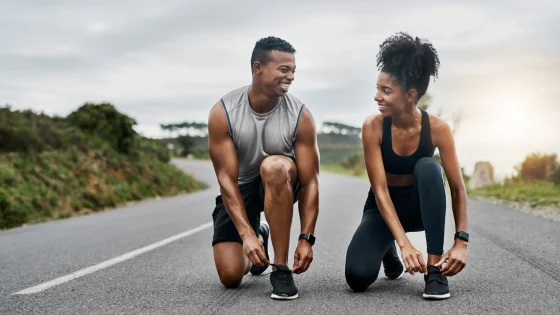couple tying shoes for cardio exercise