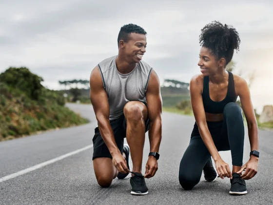 couple tying shoes for cardio exercise