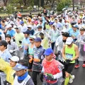 Large group of marathon runners in colorful rain ponchos at the starting line of a race